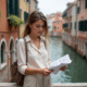 Jeune femme à Venise consulte une carte sur un pont
